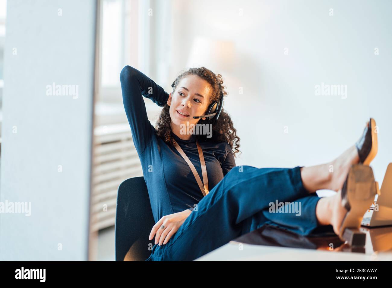 Young customer service representative talking through headset at office Stock Photo