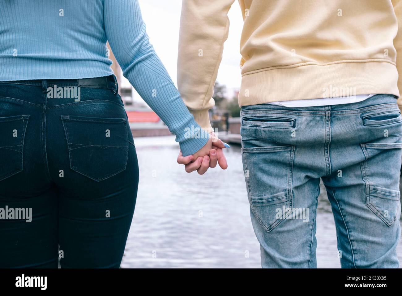 Young couple holding hands together in front of river Stock Photo