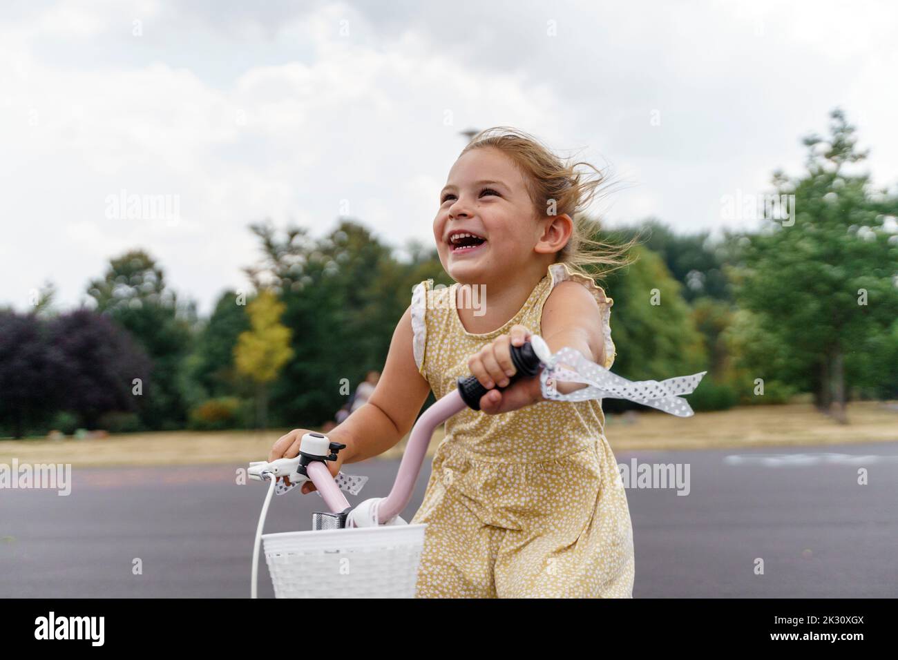 Cheerful girl enjoying cycling at park Stock Photo