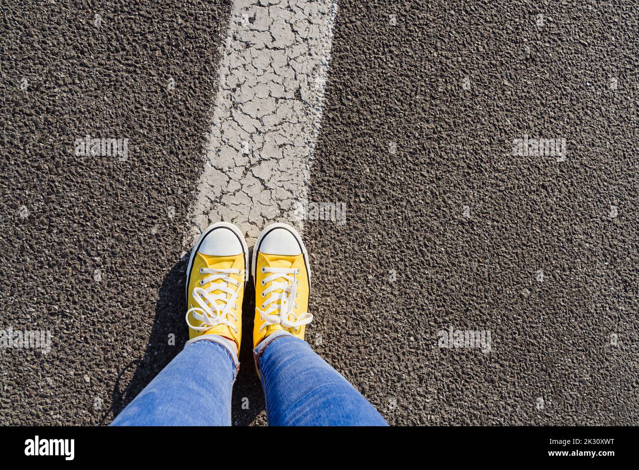 Woman standing on white painted dividing line Stock Photo