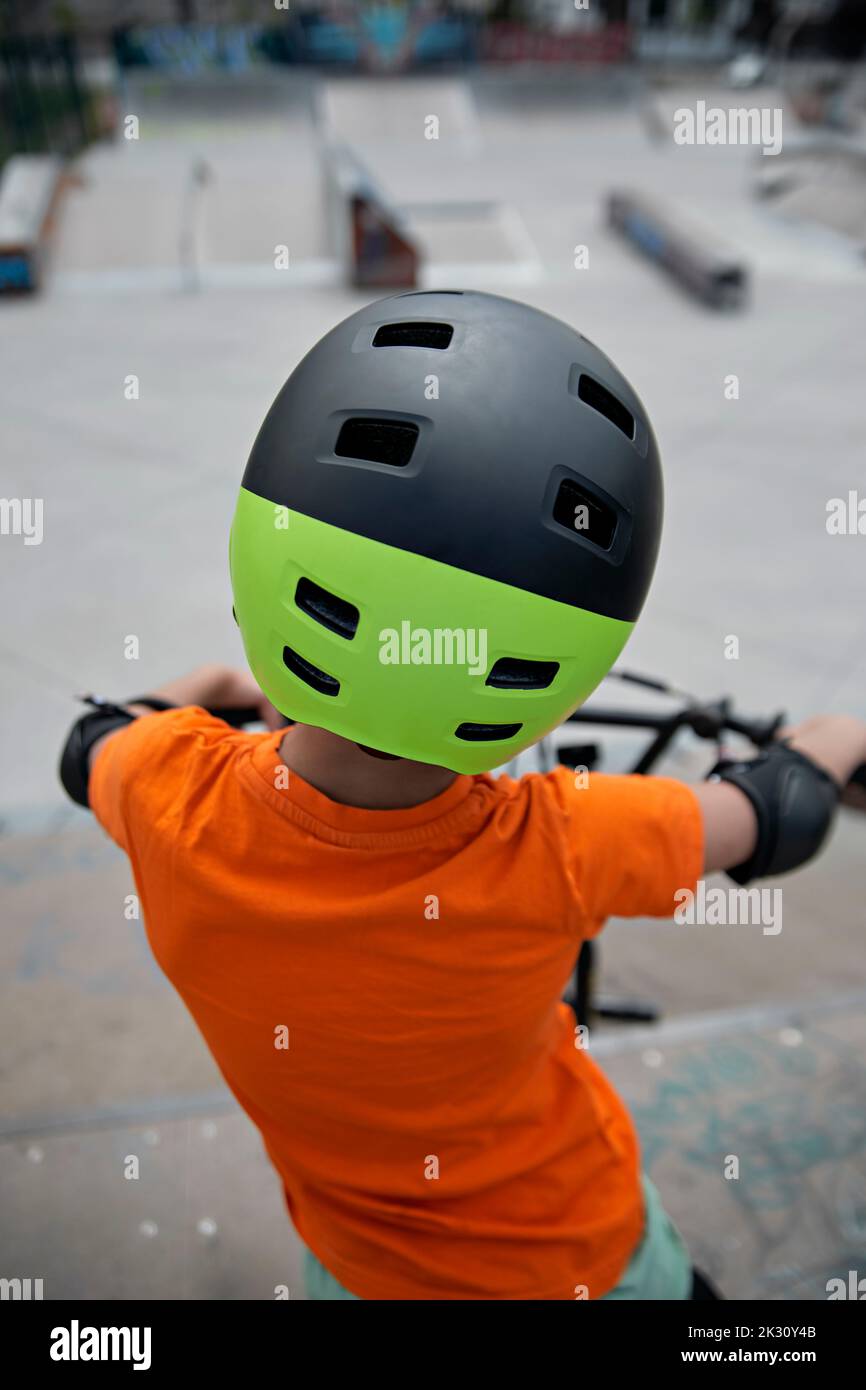 Boy with helmet on BMX bike at skate park Stock Photo