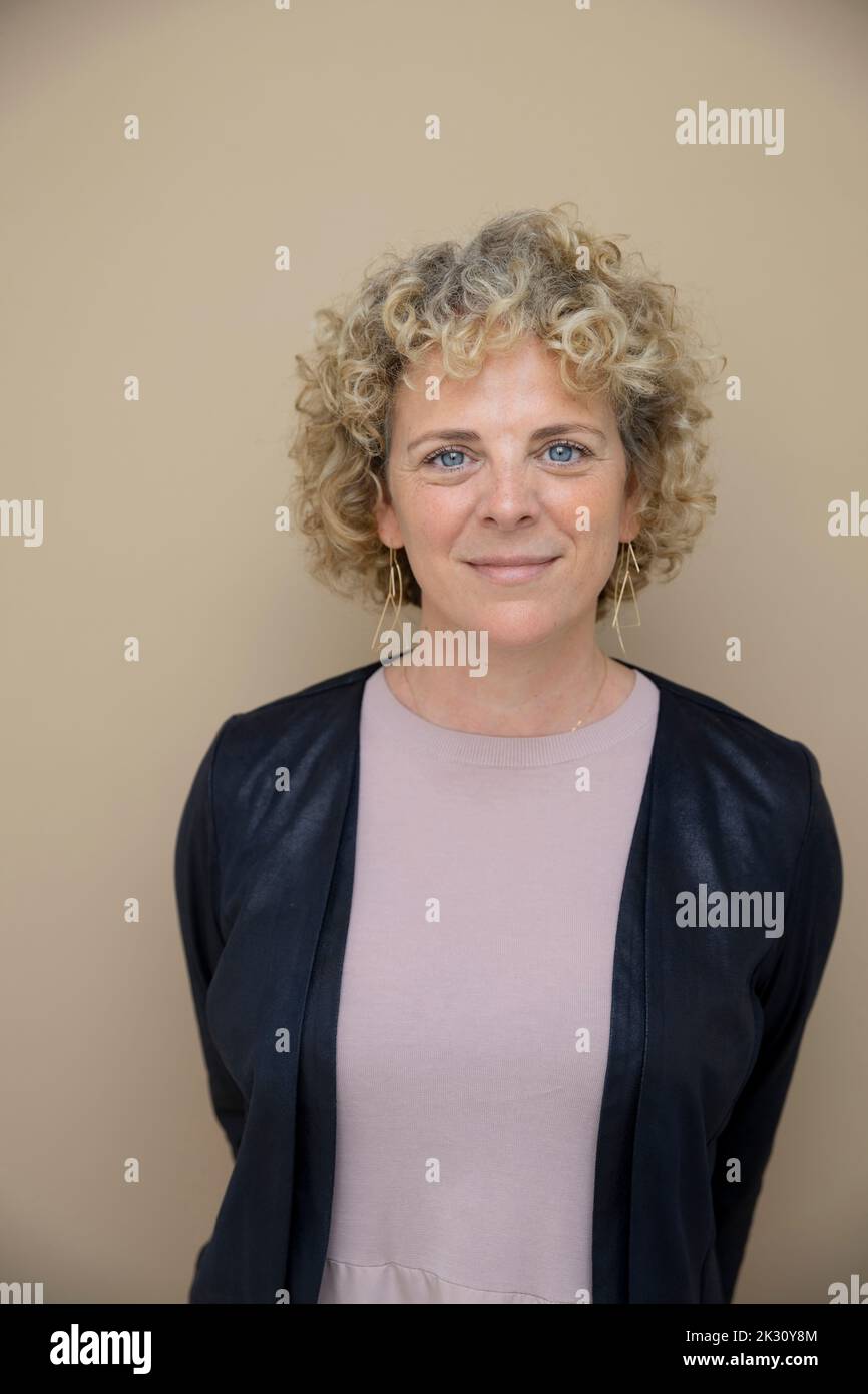 Mature businesswoman standing against brown background Stock Photo