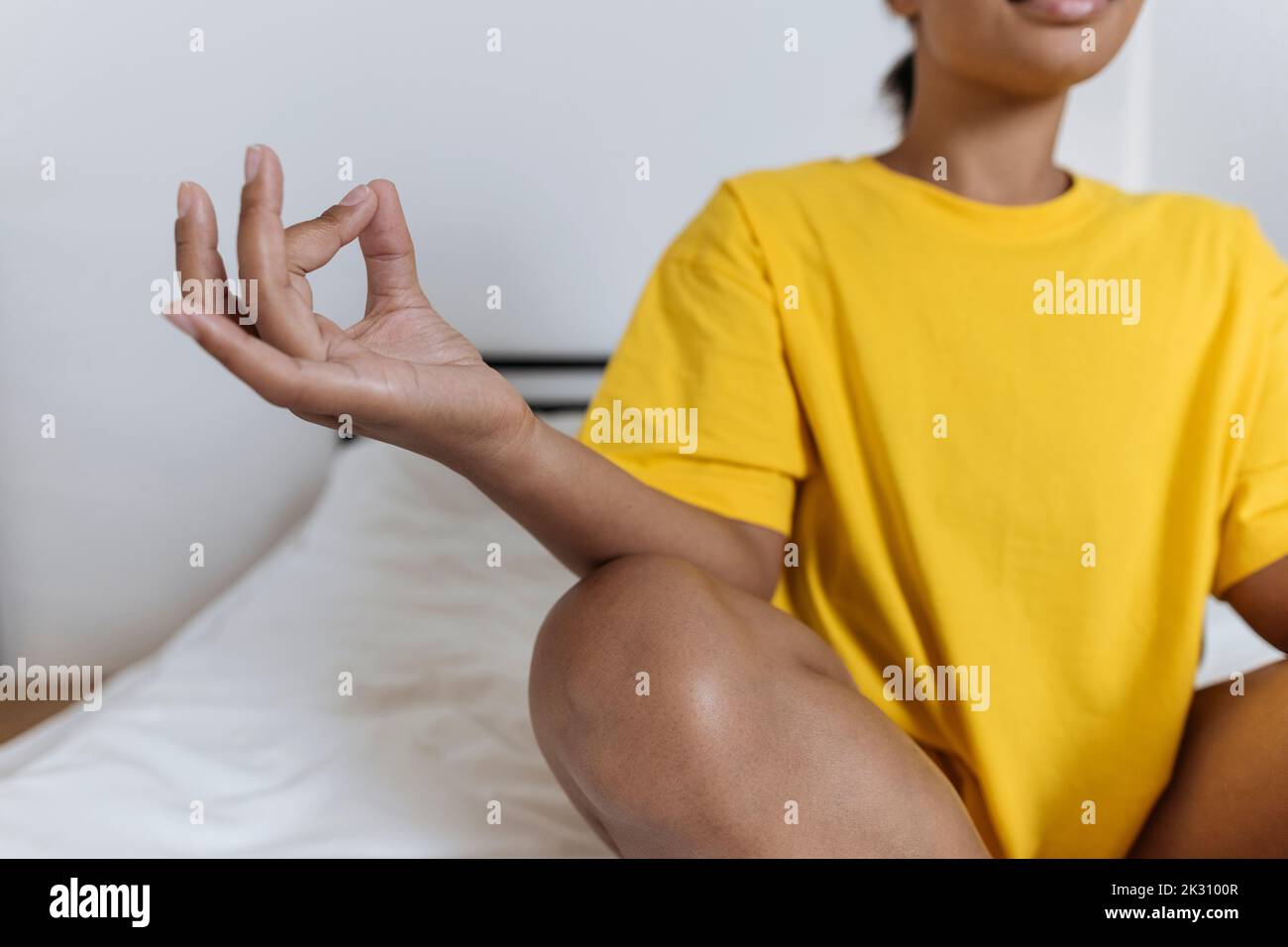 Young woman meditating in the morning sitting cross-legged on bed Stock ...