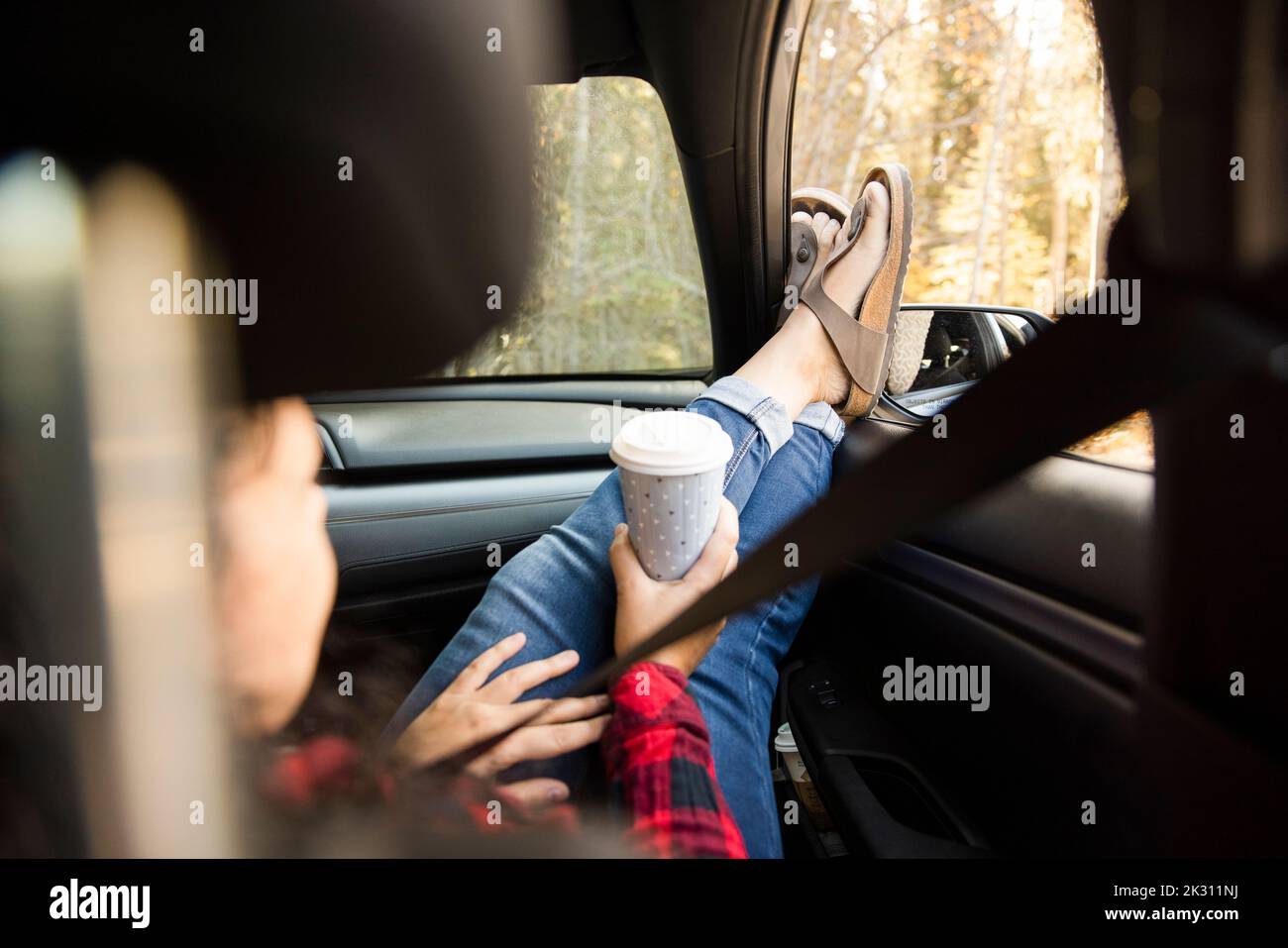 Woman relaxing in car with feet out of window Stock Photo - Alamy