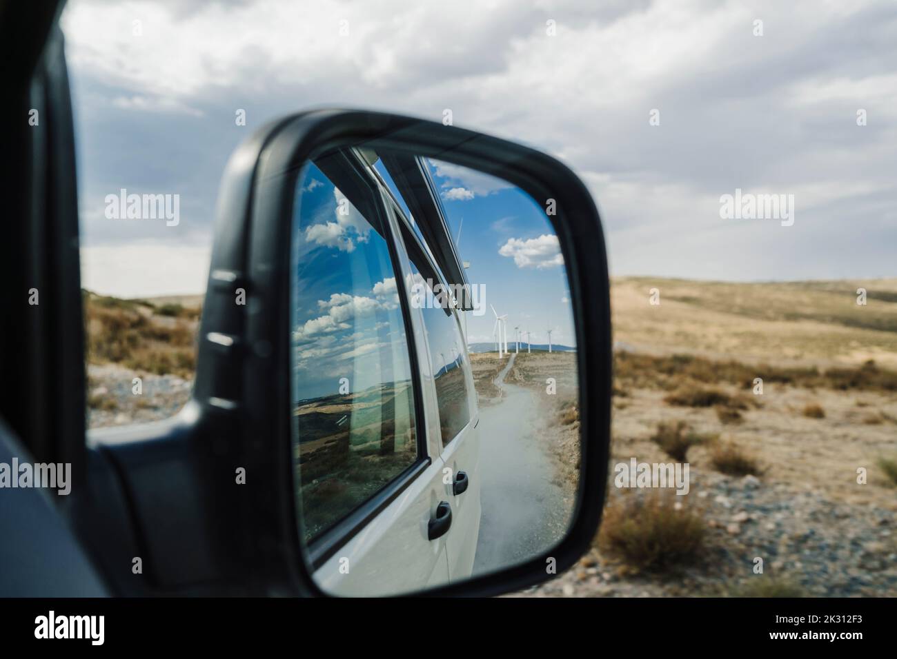 Reflection of wind farm on side mirror of van Stock Photo