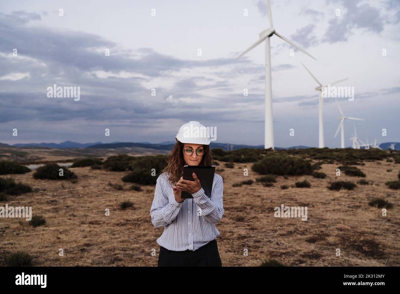 Engineer working on tablet PC at wind farm Stock Photo