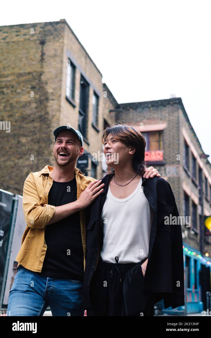 Happy gay couple walking in city Stock Photo
