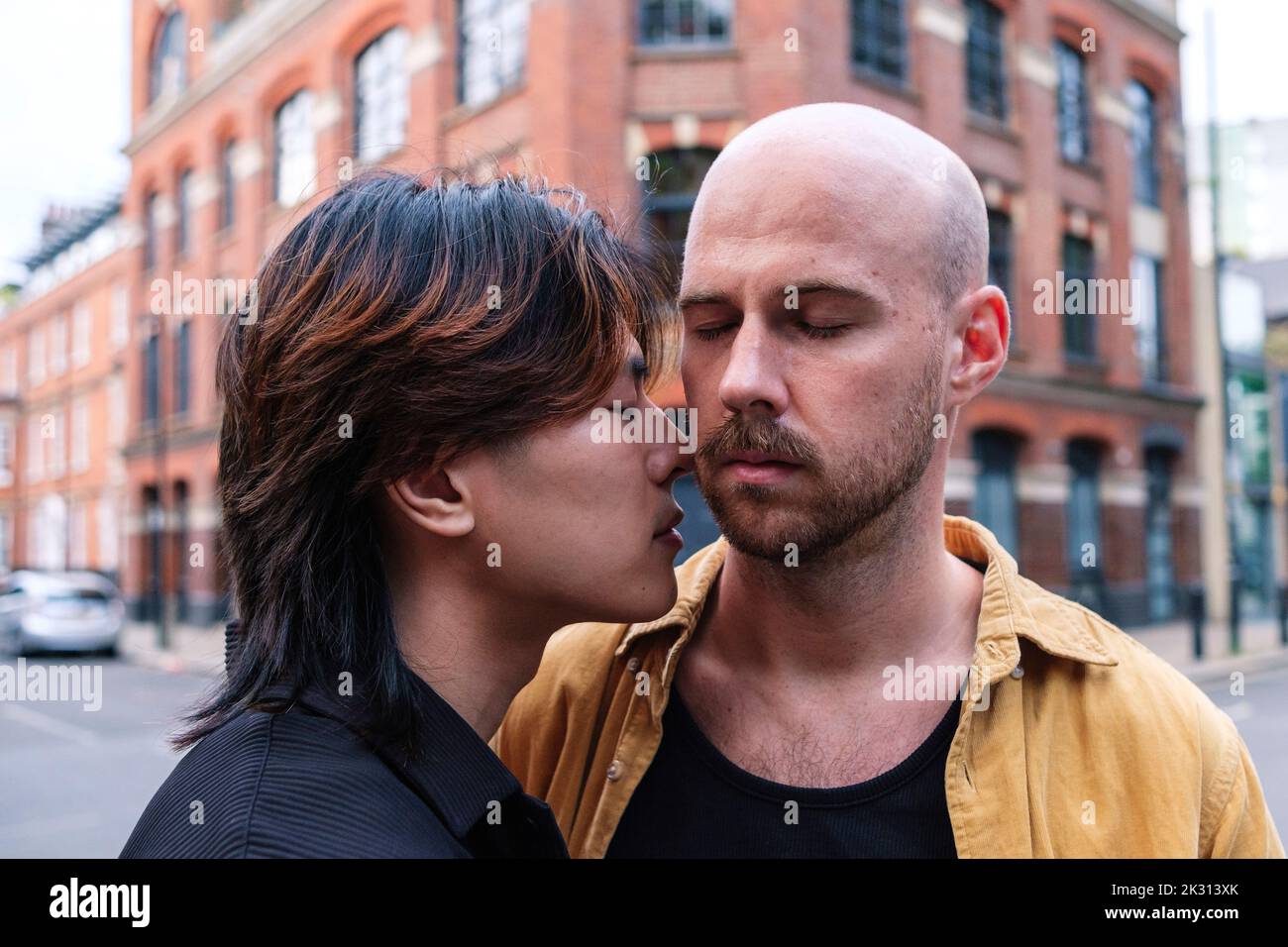 Affectionate gay couple with eyes closed romancing in city Stock Photo ...