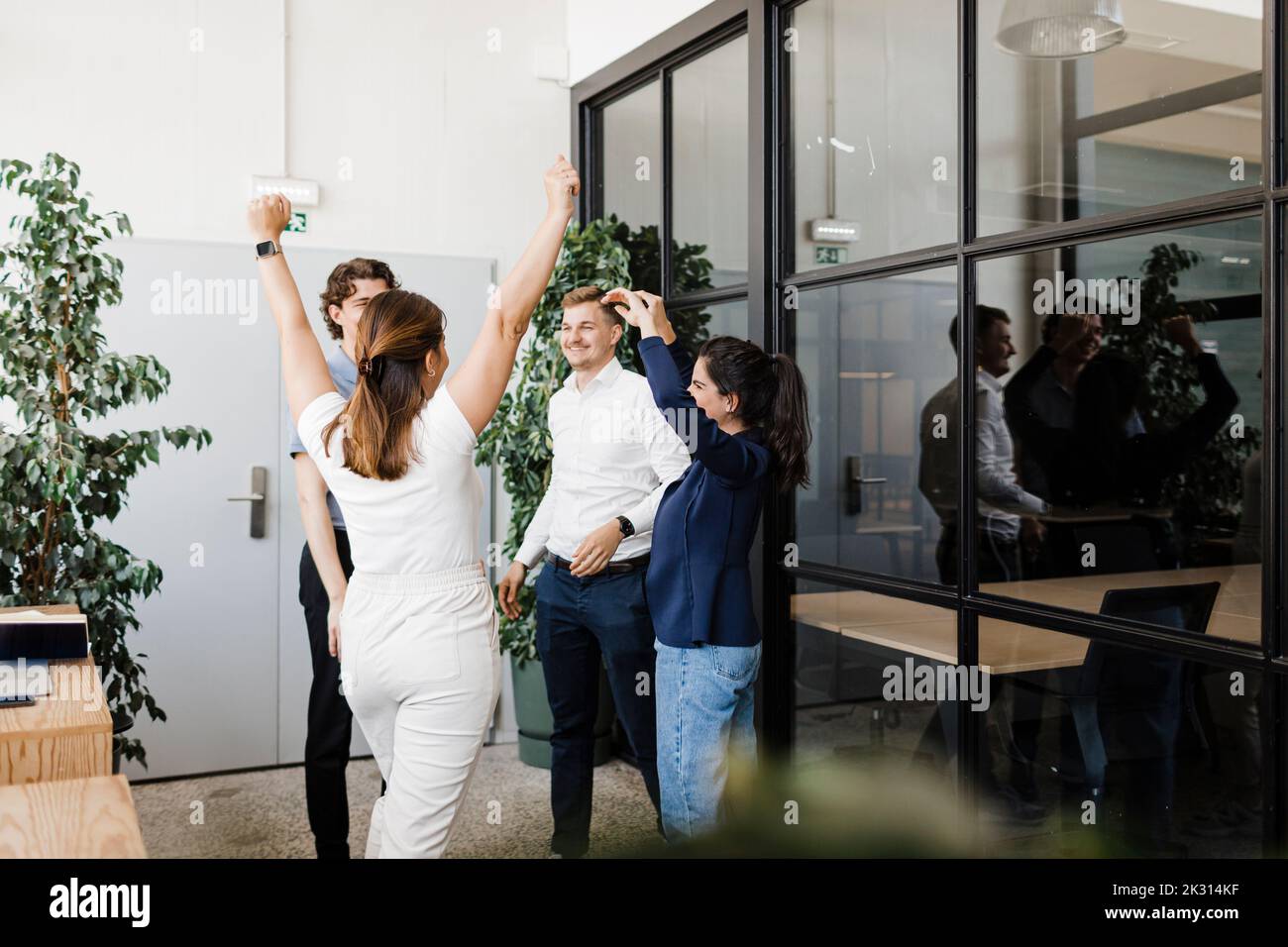 Cheerful business colleagues standing together in modern office Stock Photo