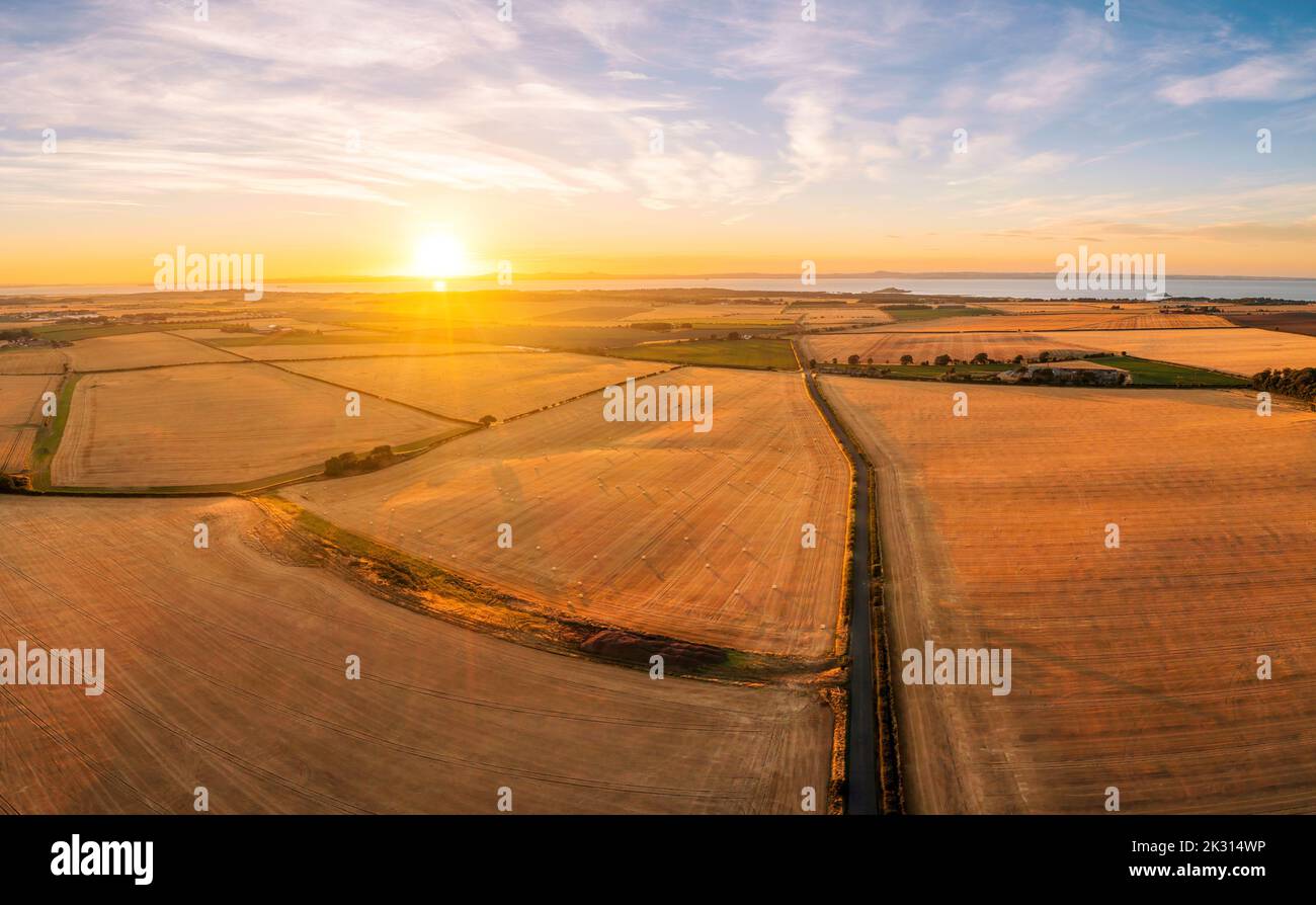 UK, Scotland, Aerial view of harvested barley fields at summer sunset