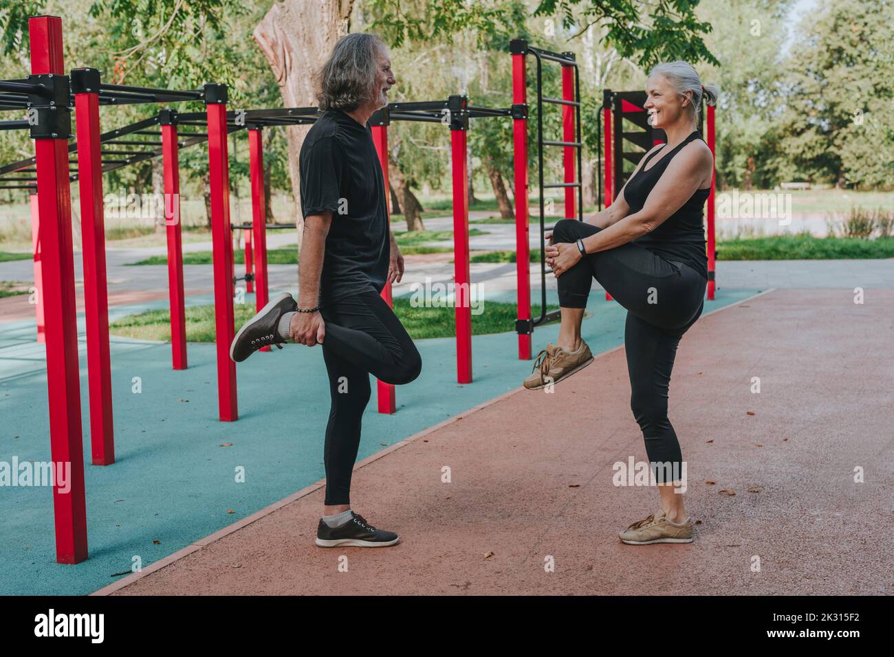 Active couple stretching legs in park Stock Photo