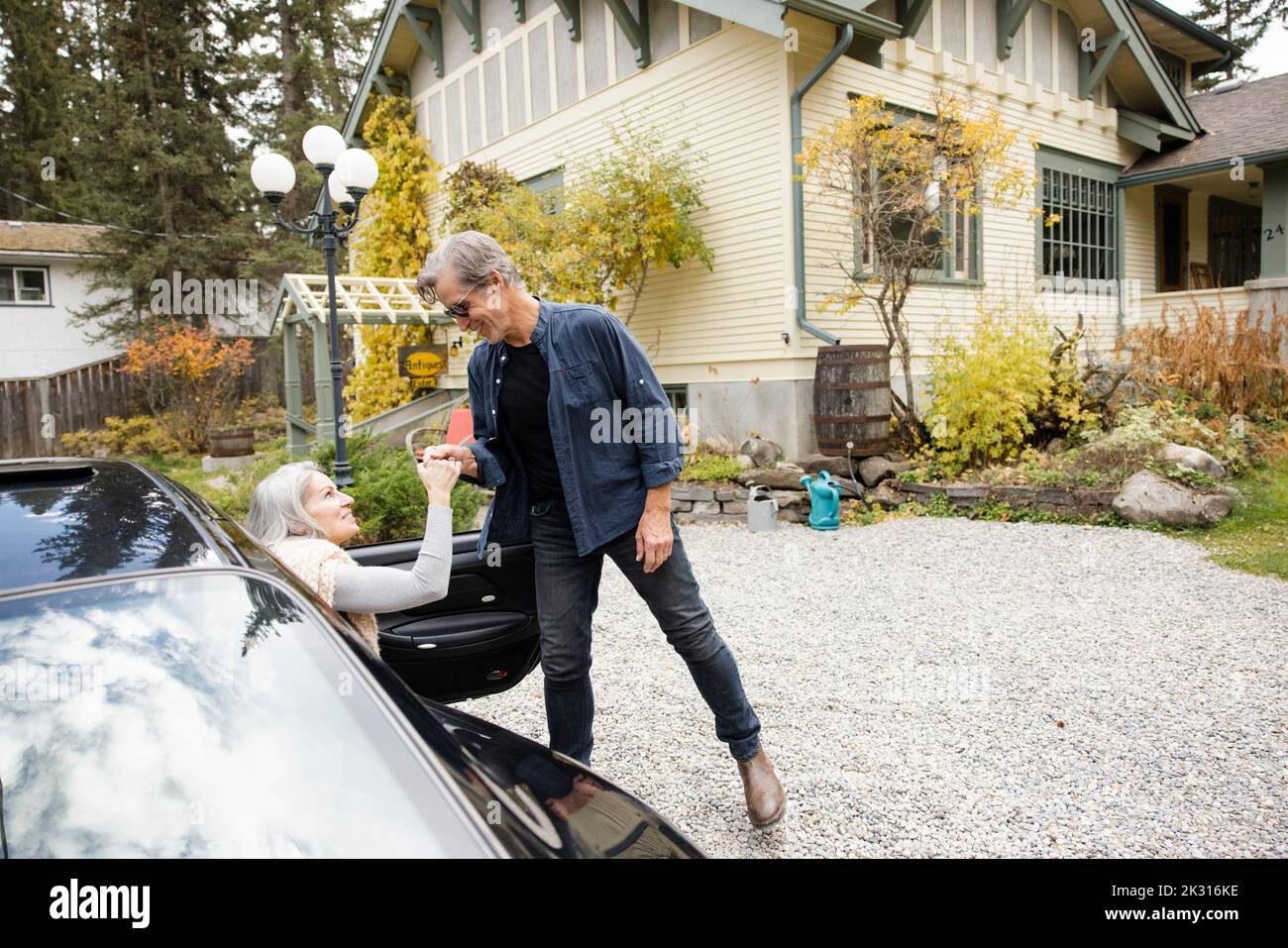 Man helping wife out of car Stock Photo