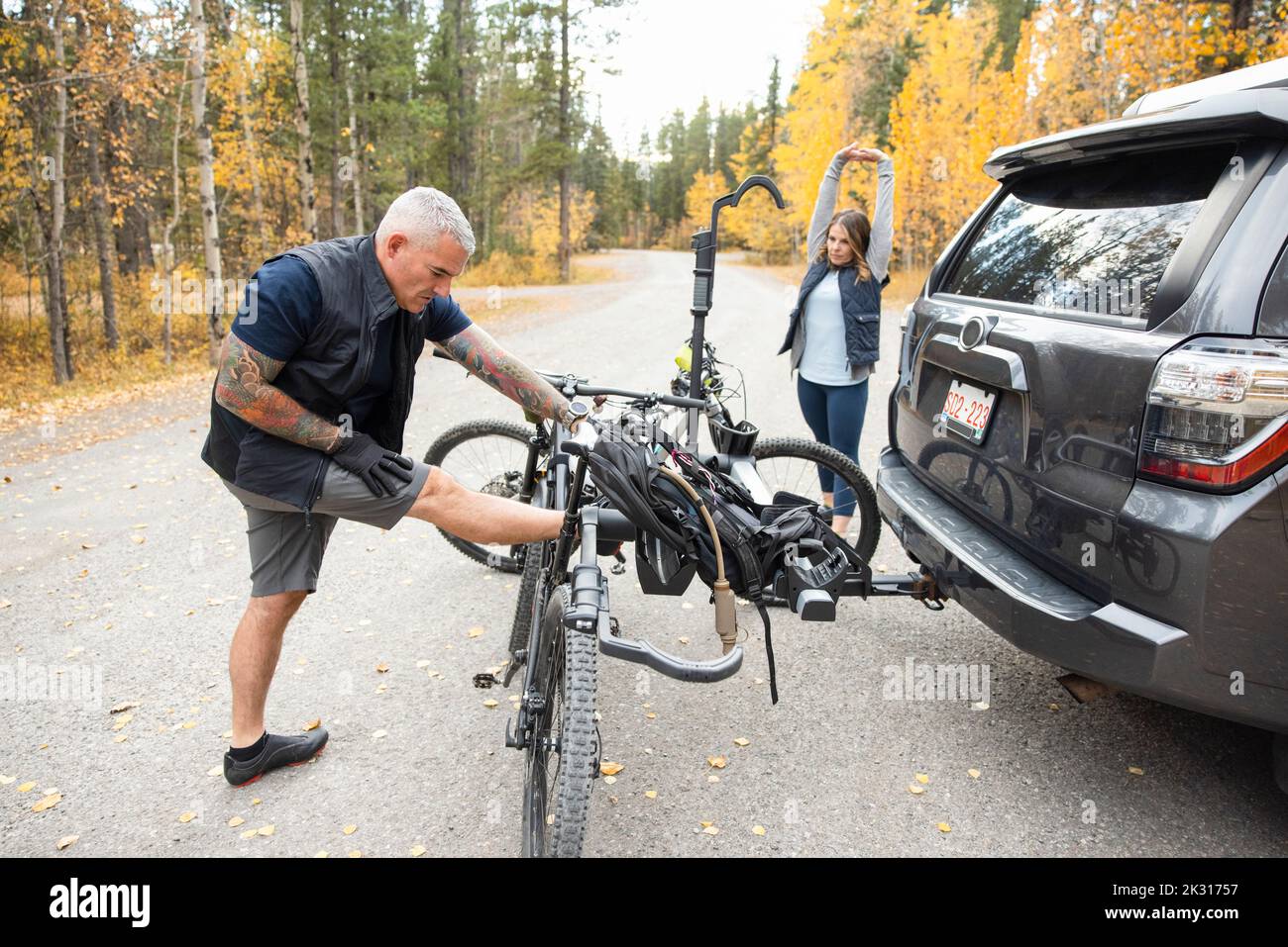 Couple stretching next to SUV after bike ride Stock Photo Alamy
