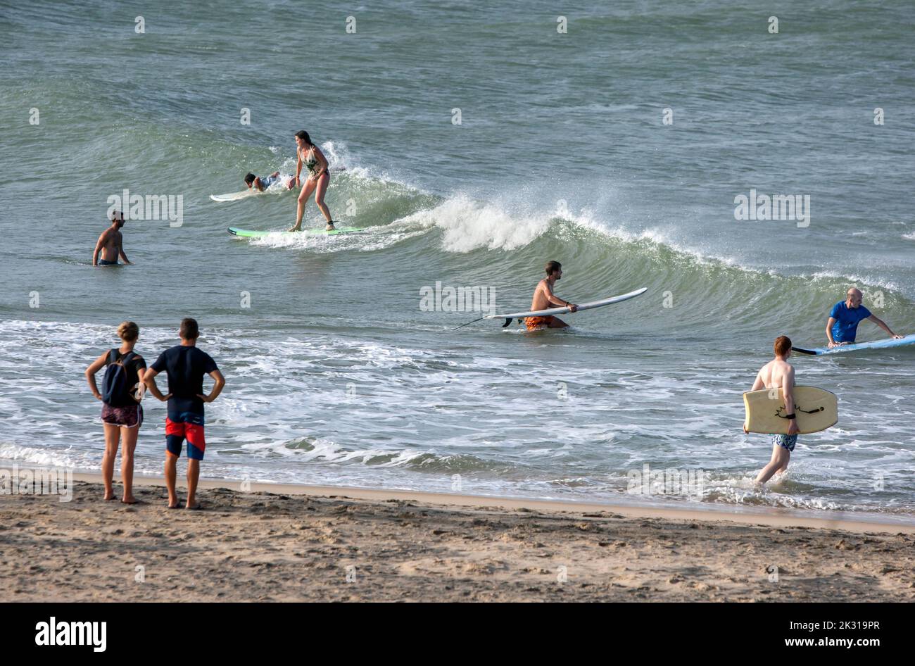Foreign surfers ride the shore break waves off Elephant Rock near Arugam Bay on the east coast of Sri Lanka. Stock Photo