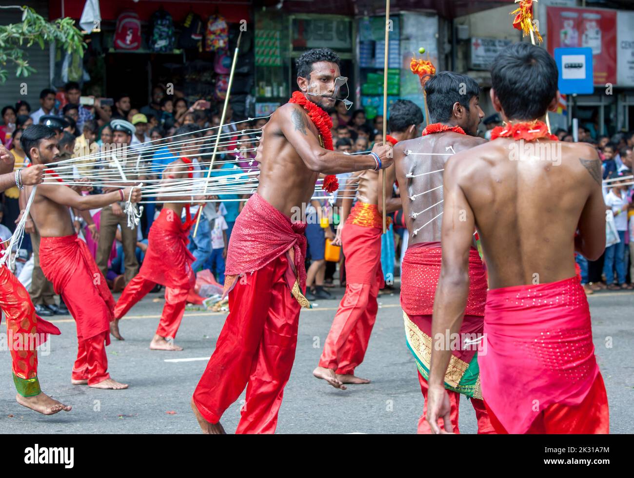 Tamil Kavadi Dancers with hooks piercing their bodies perform during the Day Perahera at Kandy in Sri Lanka. Stock Photo