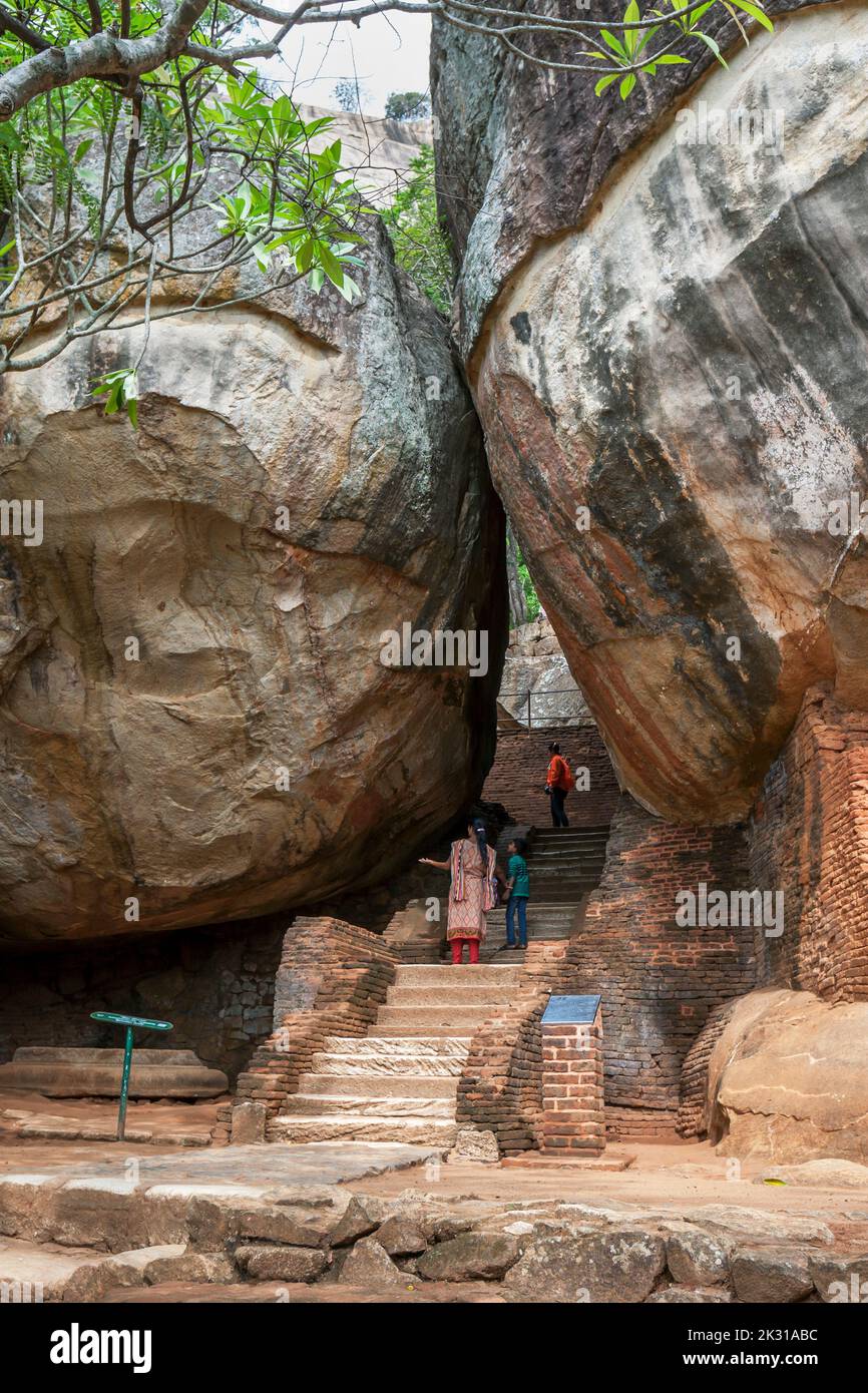 Visitors to Sigiriya Rock Fortress at Sigiriya in central Sri Lanka admire the huge rocks at Boulder Arch Number One. Stock Photo