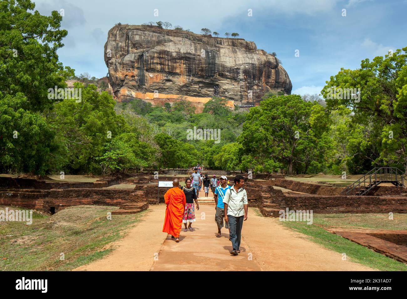 SIGIRIYA, SRI LANKA - AUGUST 18, 2019 : Visitors to Sigiriya Rock Fortress at Sigiriya in central Sri Lanka walk through the ruins of the Royal Garden Stock Photo