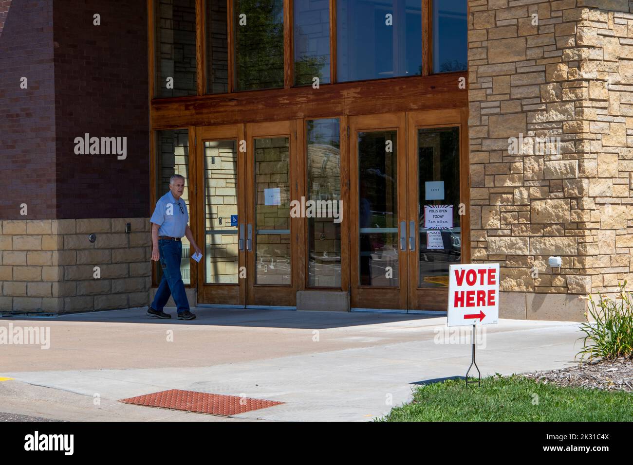 Vadnais Heights, Minnesota. Primary voting. Senior entering polling station with registration card in his hand. Stock Photo