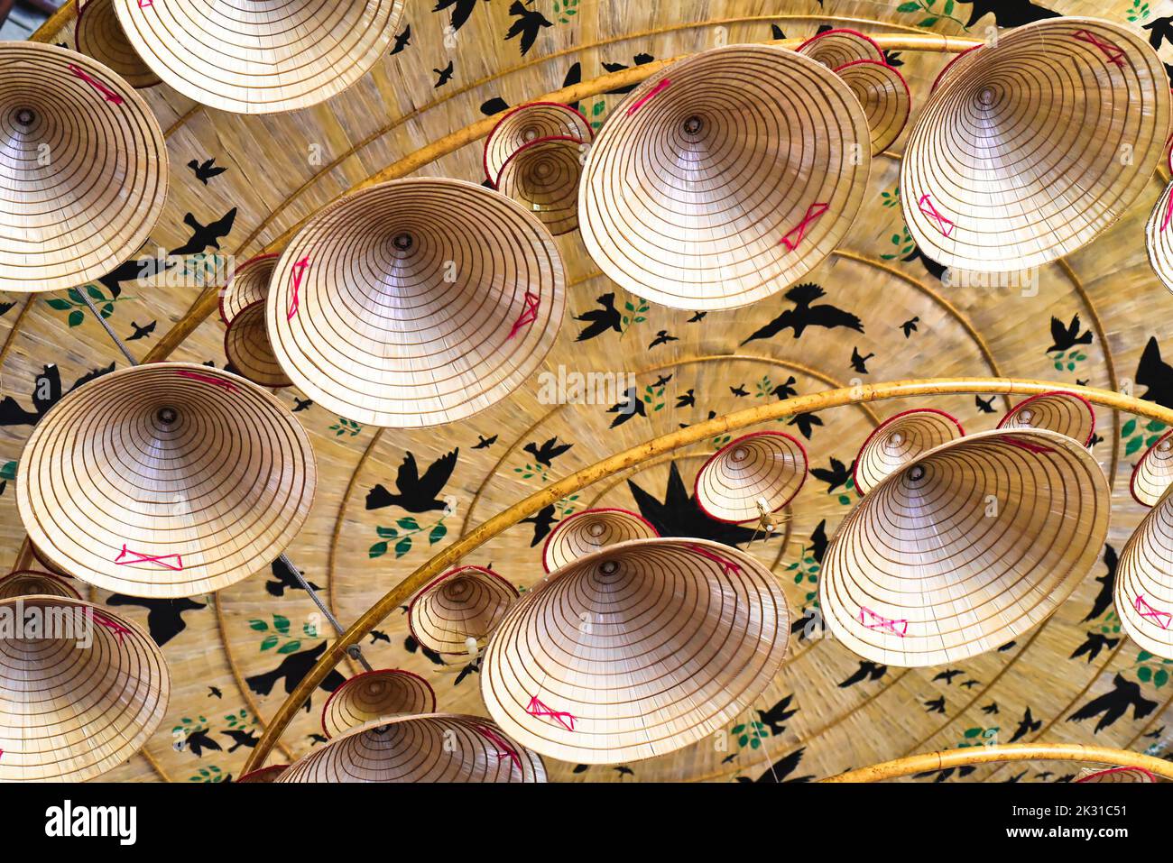 Many similar traditional Vietnamese conical hats attached to the ceiling for decoration a holiday Stock Photo