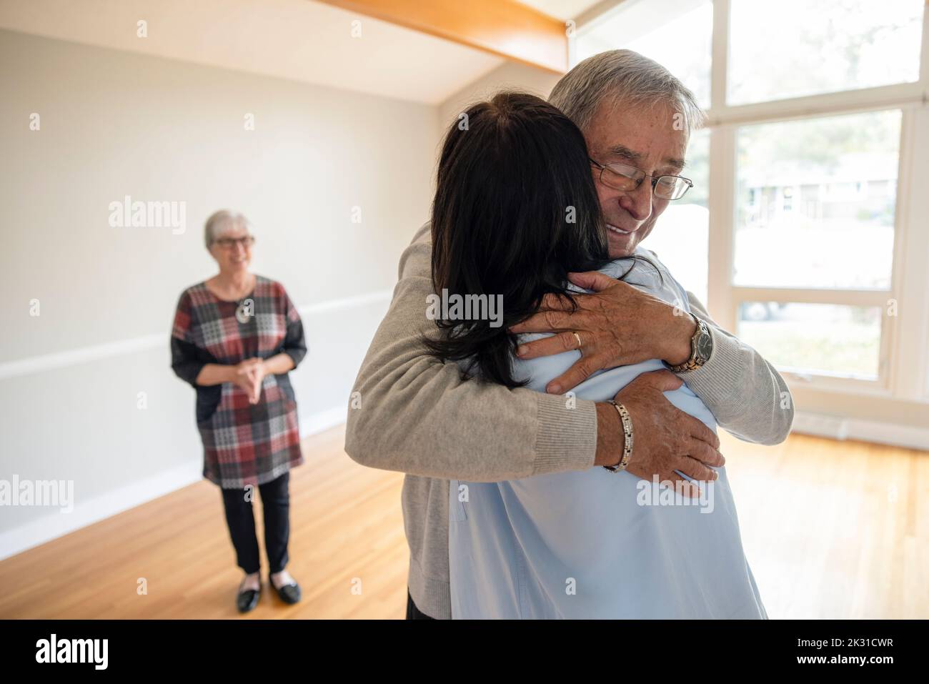 Daughter hugging senior father in new home Stock Photo