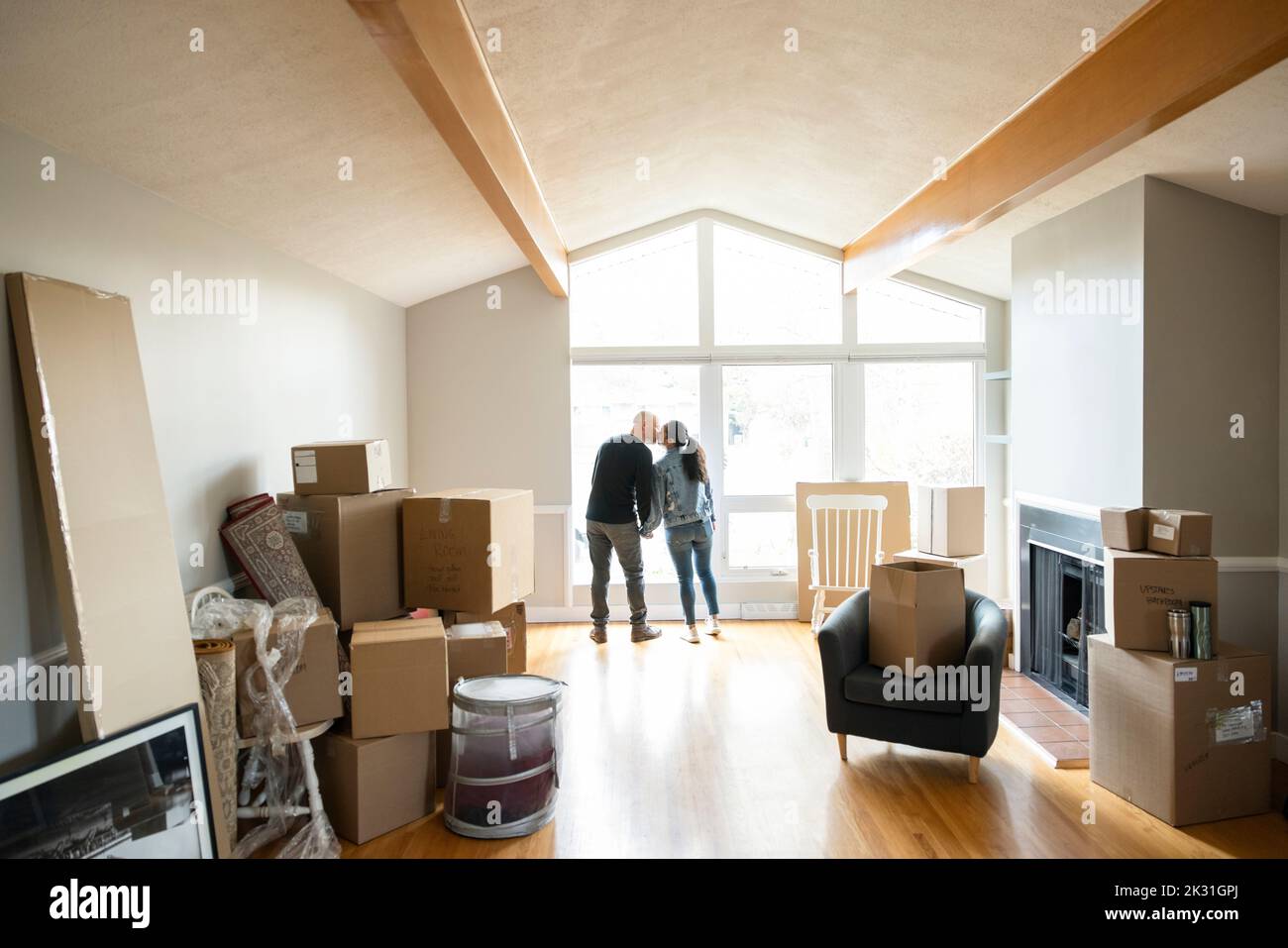 Couple kissing at window in new house with moving boxes Stock Photo Alamy