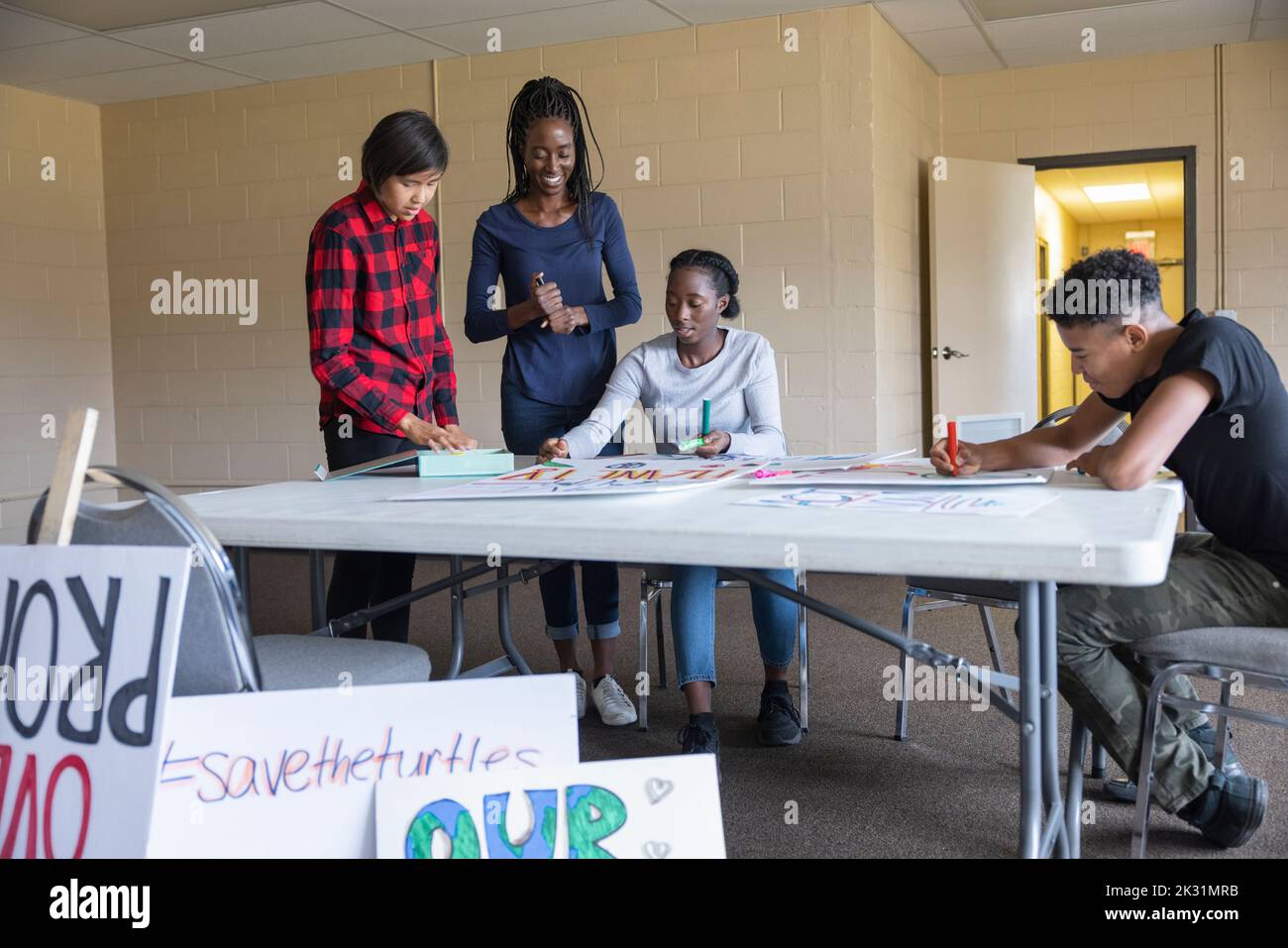 Teen environmental activists making posters in community center Stock Photo