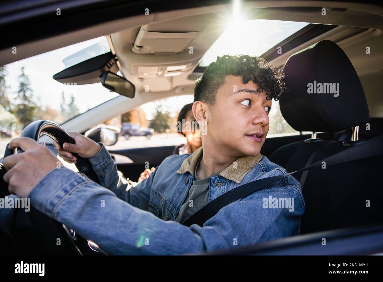 Driving instructor looking over shoulder in car Stock Photo Alamy