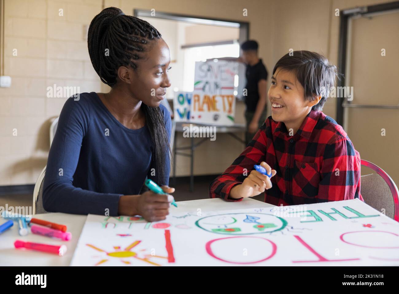 Teen environmental activists coloring poster in community center Stock Photo