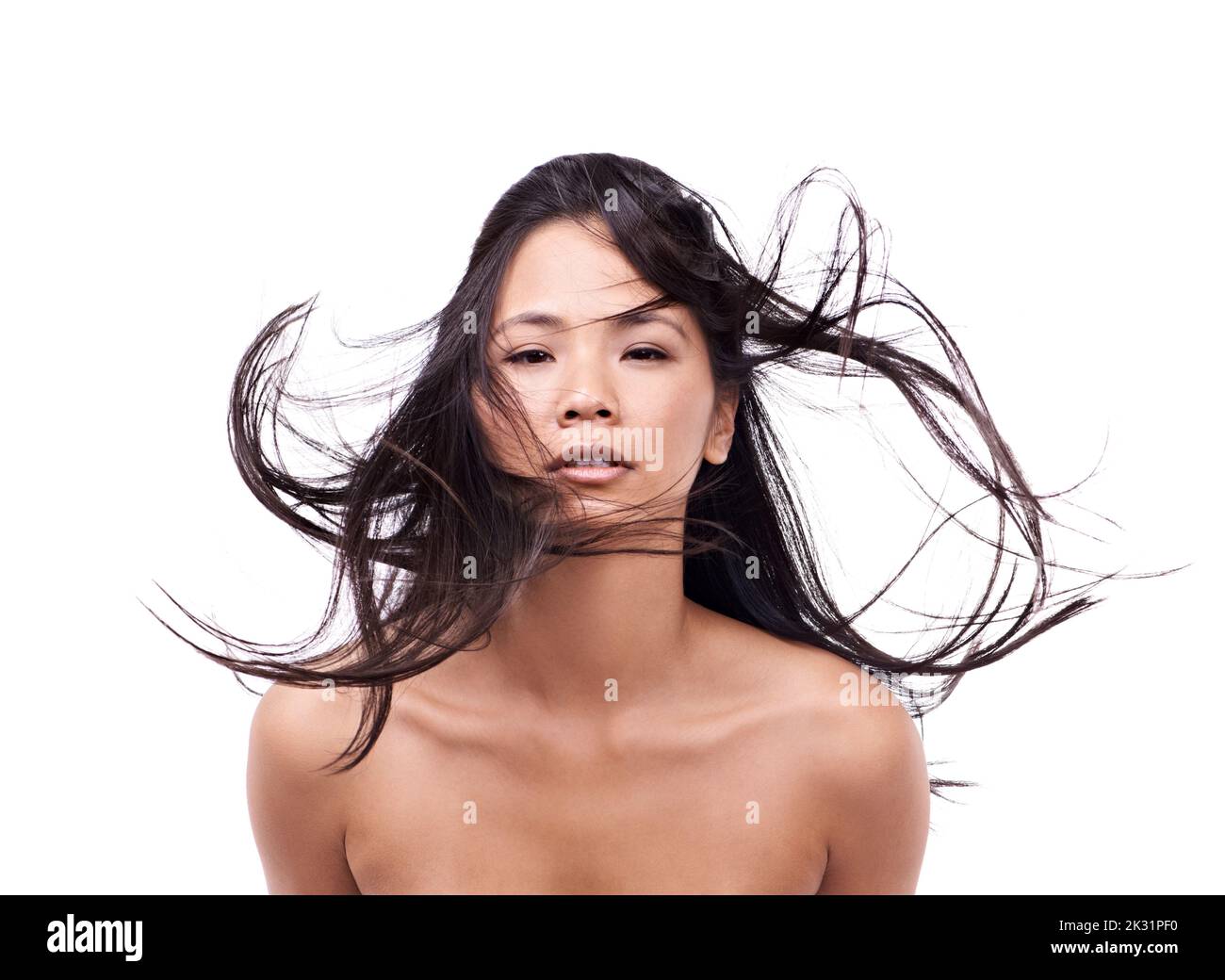 Windswept locks. a beautiful young oriental woman against a white background. Stock Photo
