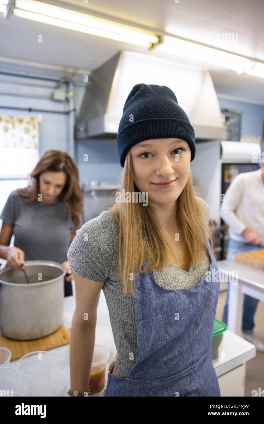 Portrait confident teen girl volunteering in community soup kitchen