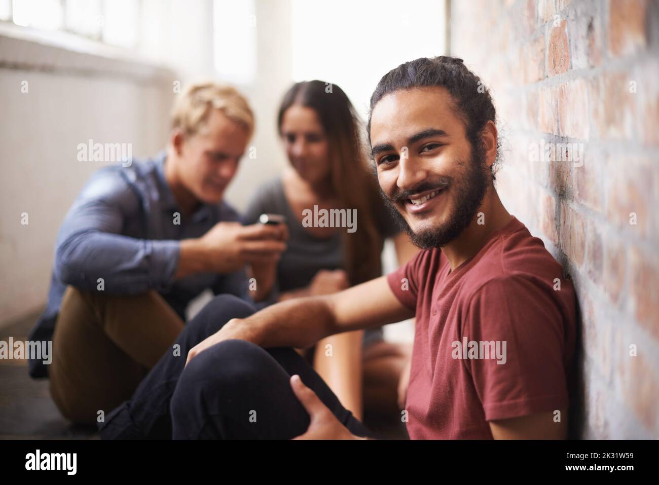 Looking forward to the next class. three students relaxing in the hallway. Stock Photo