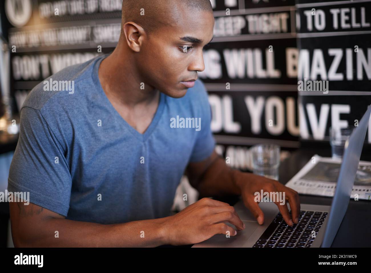Head down, production up. a handsome young man using his laptop in a coffee shop. Stock Photo