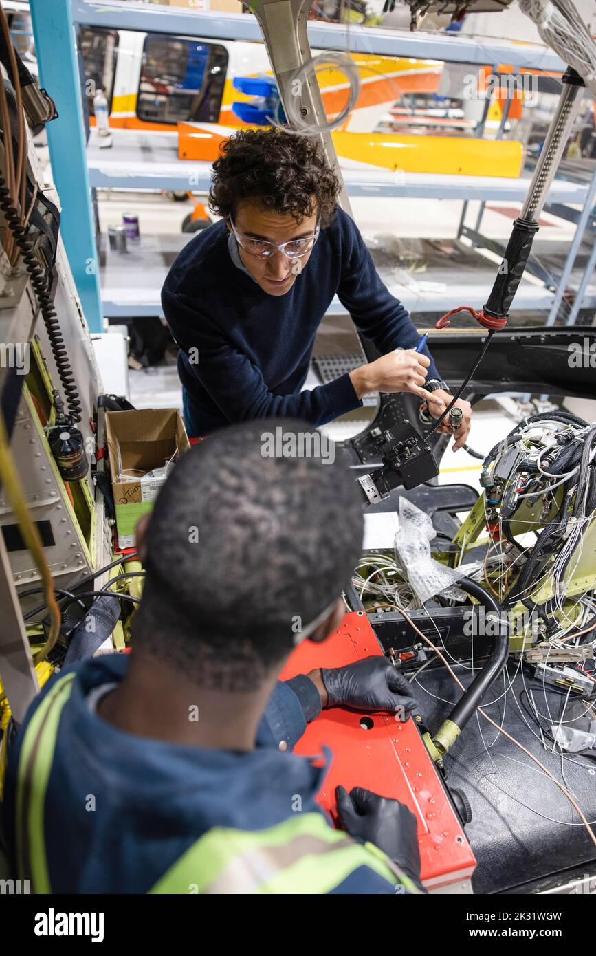 Technicians working on helicopter interior Stock Photo - Alamy