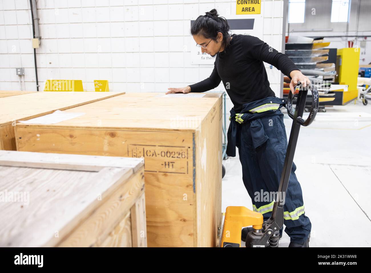 Technician selecting crate in loading bay Stock Photo