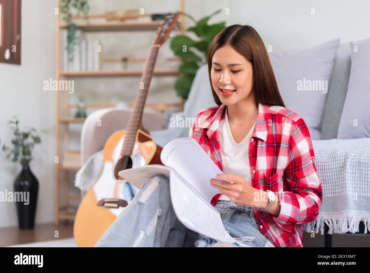 Writing Sign Singer Guitar and singer concept, Young asian woman is composing new song and ...