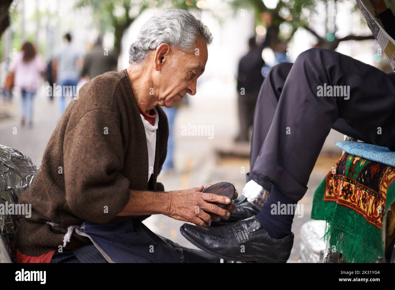 Keeping the businessmens shoes shiney. a shoe shiner shining a