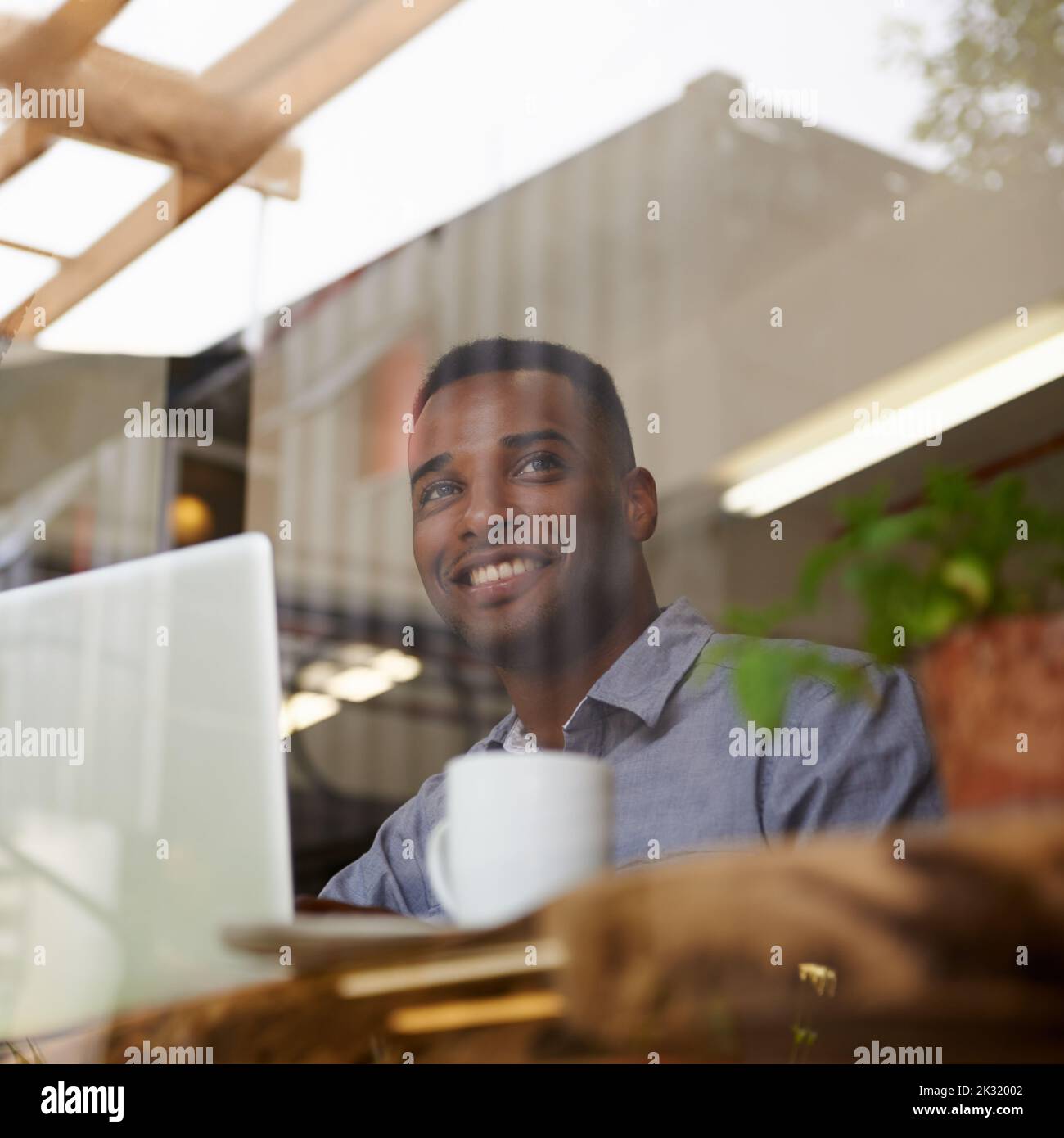 Hes got the coffee buzz look. a young african man using his laptop in a coffee shop. Stock Photo