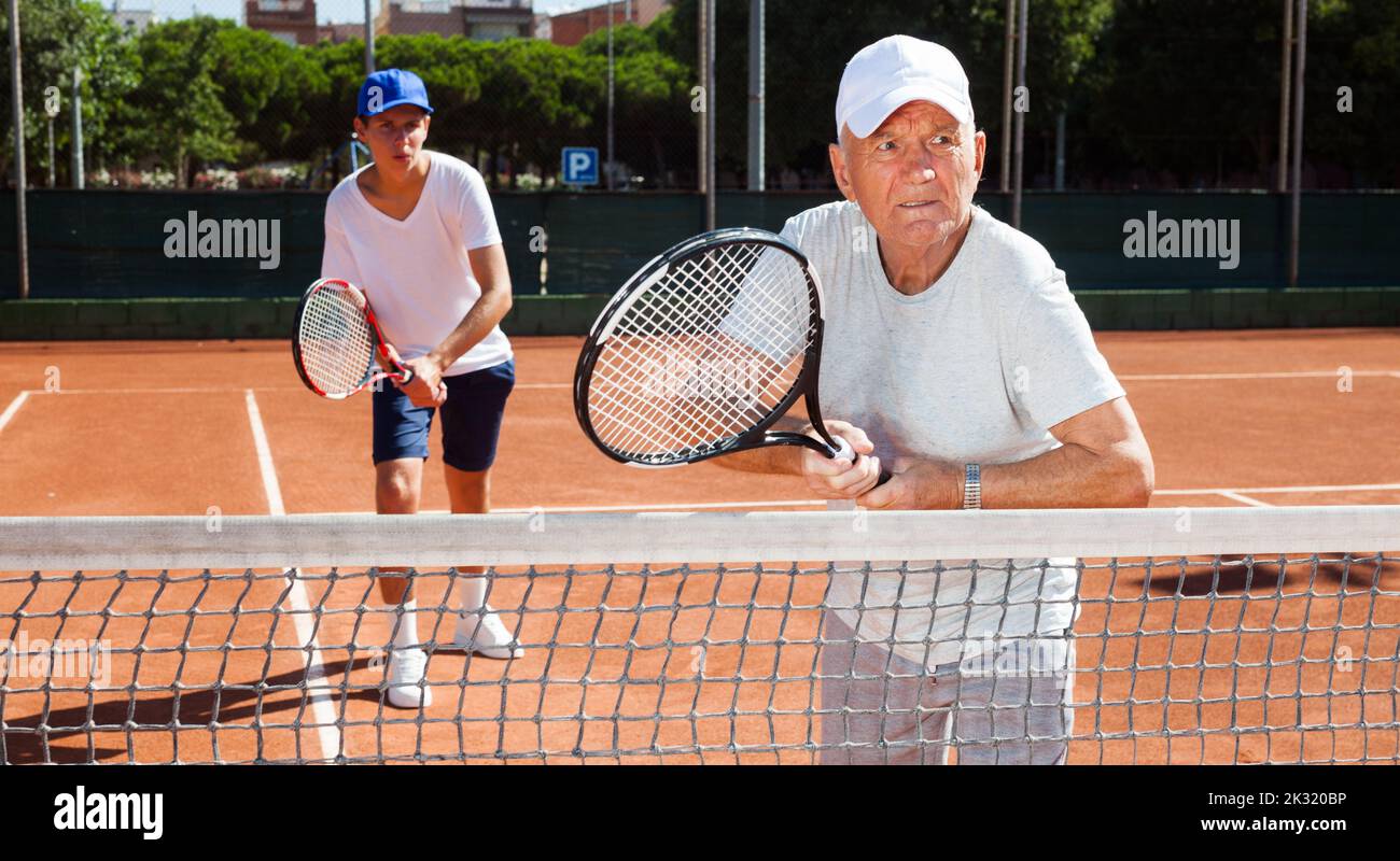 tennis players of different generations playing tennis court Stock