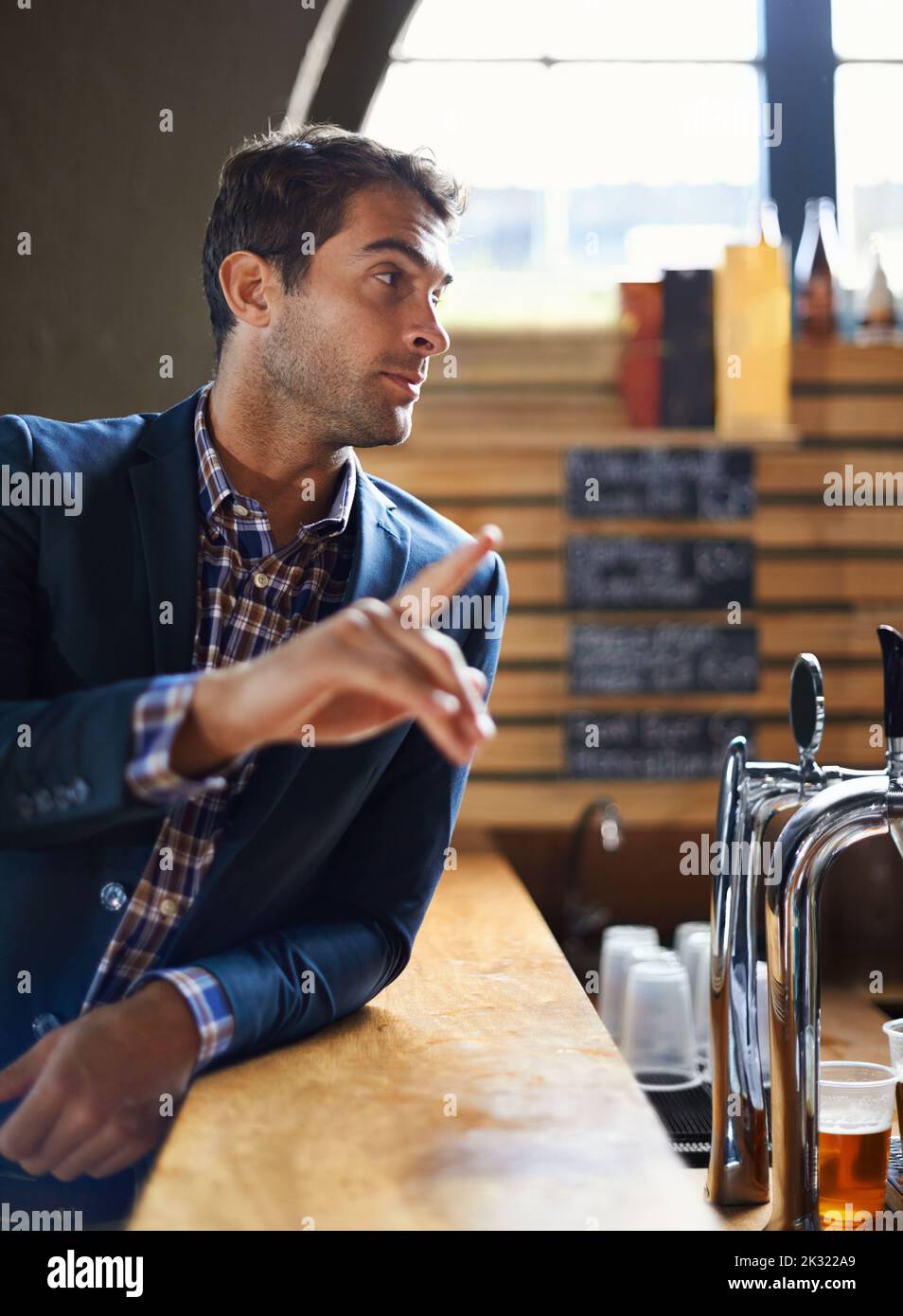 Ordering a beer from the bar. a handsome young man ordering something