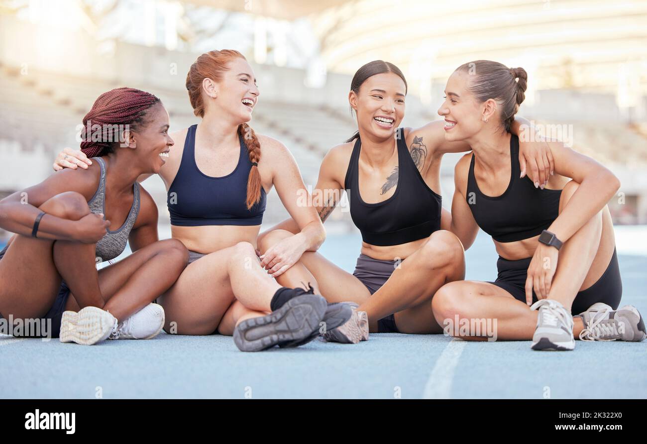 Happy, diversity and sports women, friends and athletes break from marathon training workout on running track at stadium arena outdoors. Smile Stock Photo