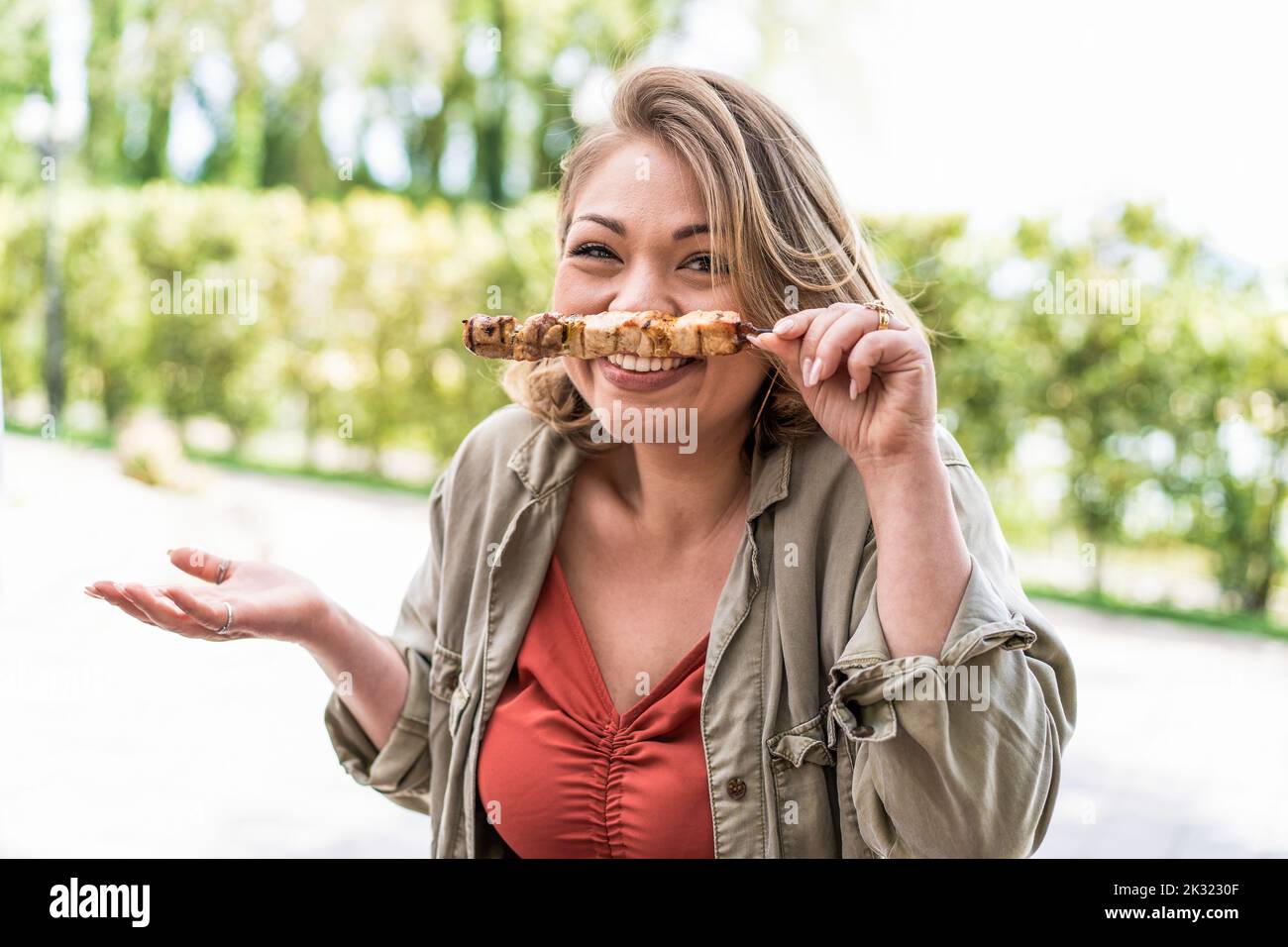 Lady Fat Fun Young chubby woman having fun in the parkland at barbecue making faces ...