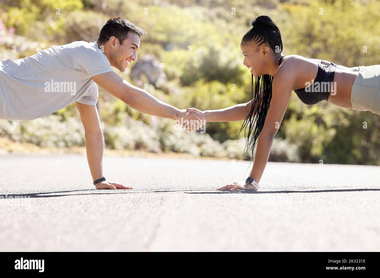 Motivation, fitness and handshake by exercise partnership deal with athletic couple shaking hands in workout challenge outdoors. Friends, hands and Stock Photo