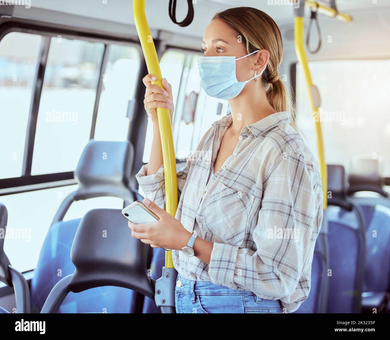 Covid, face mask and public transport with woman in a bus or train on commute into city or work during coronavirus pandemic. Travel, precaution and Stock Photo