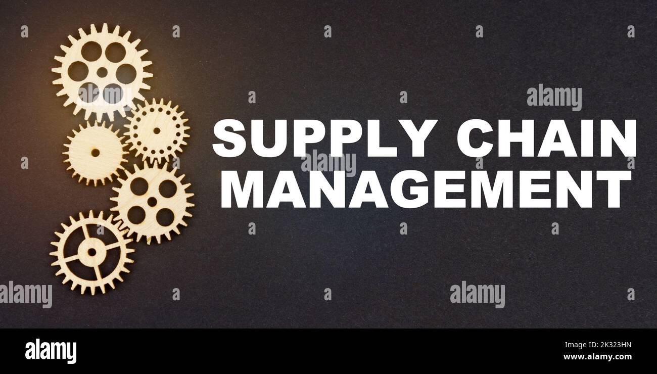 Business and industry concept. On a black background, gears and the inscription - SUPPLY CHAIN MANAGEMENT Stock Photo