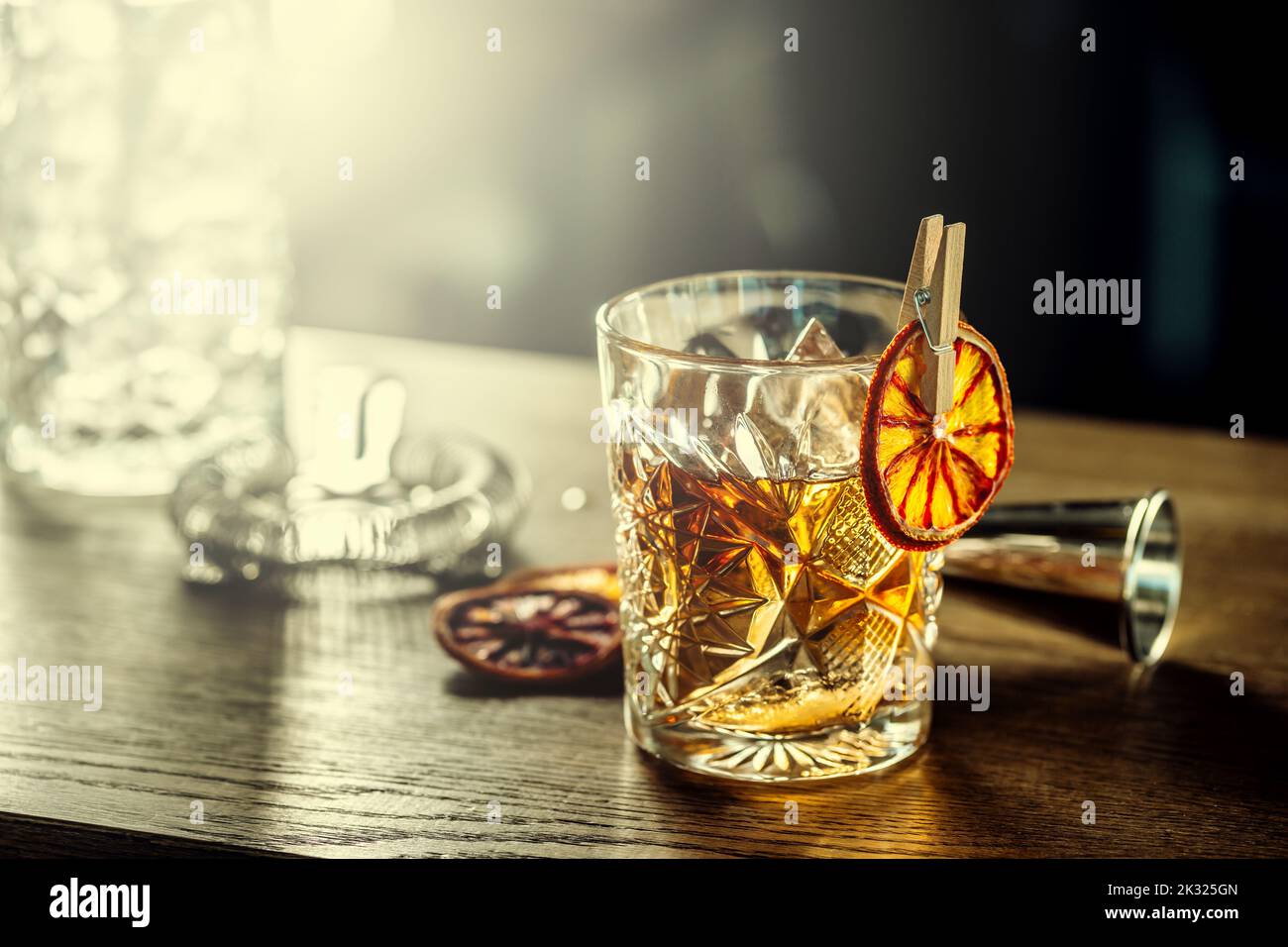 Old fashioned classic cocktail drink in crystal glass on bar counter. Stock Photo