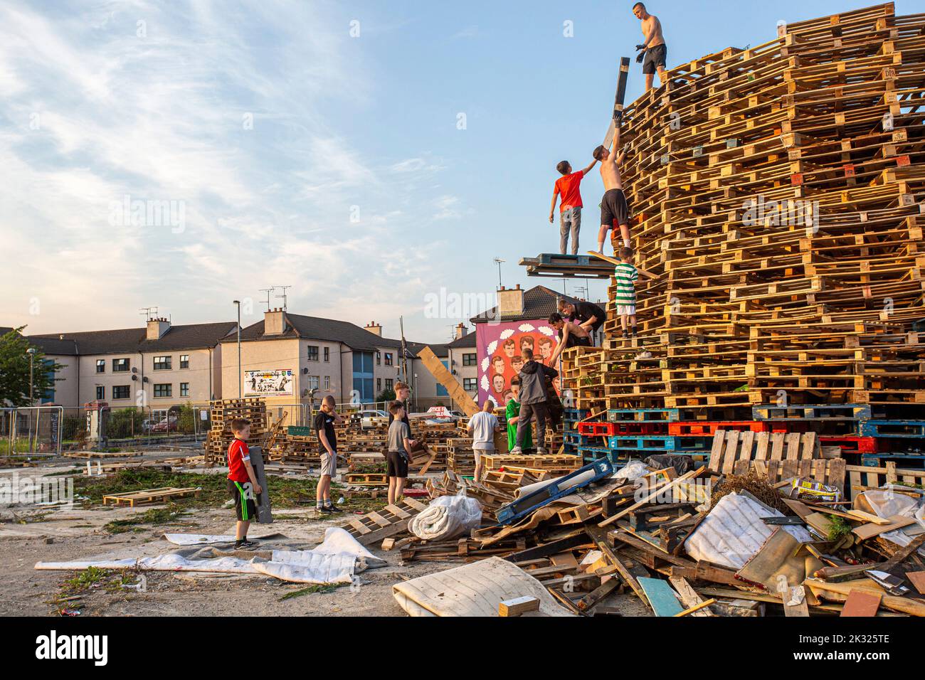 Kids stack pallets over the weekend in preparation for the bonfire marking a Catholic feast day of the Assumption of the Virgin Mary in the Bogside. Stock Photo