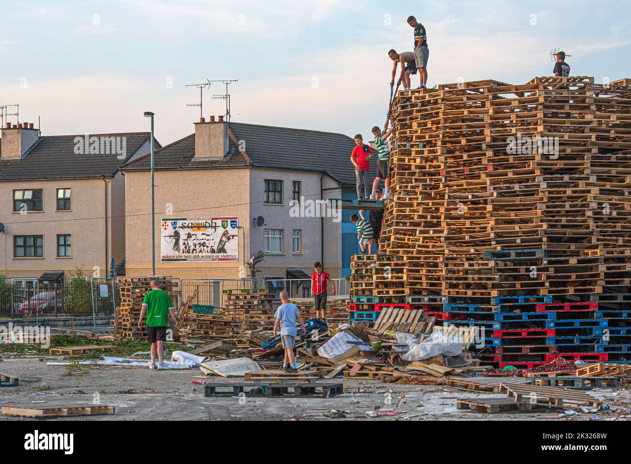 Kids stack pallets over the weekend in preparation for the bonfire marking a Catholic feast day of the Assumption of the Virgin Mary in the Bogside. Stock Photo