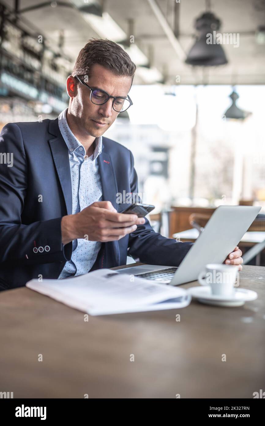 A businessman in a restaurant having coffee and taking care of his business. Stock Photo