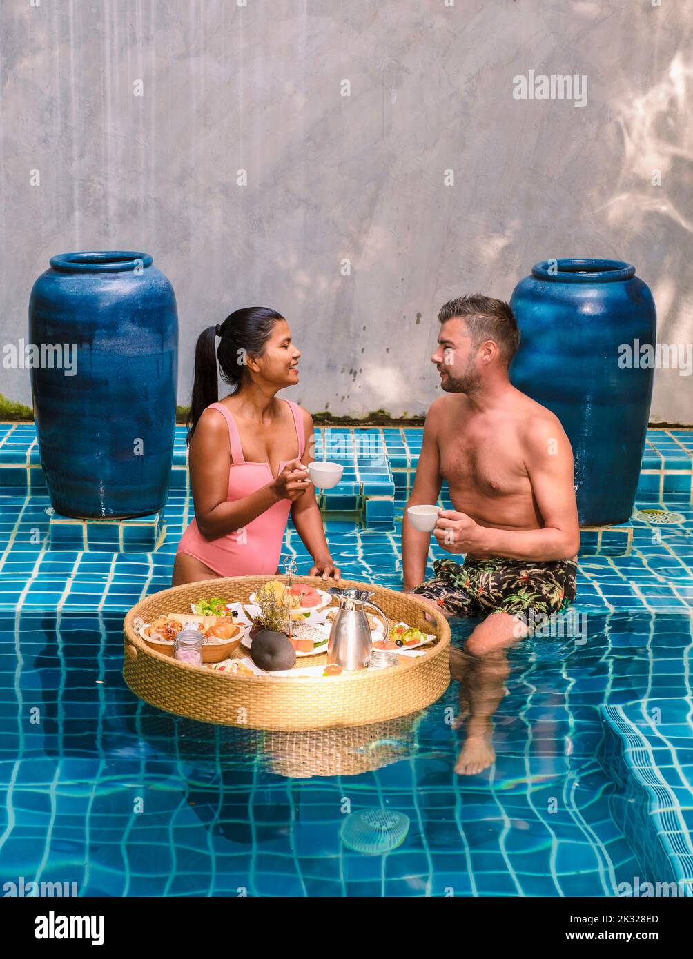 A couple having breakfast in the swimming pool , Asian women and ...