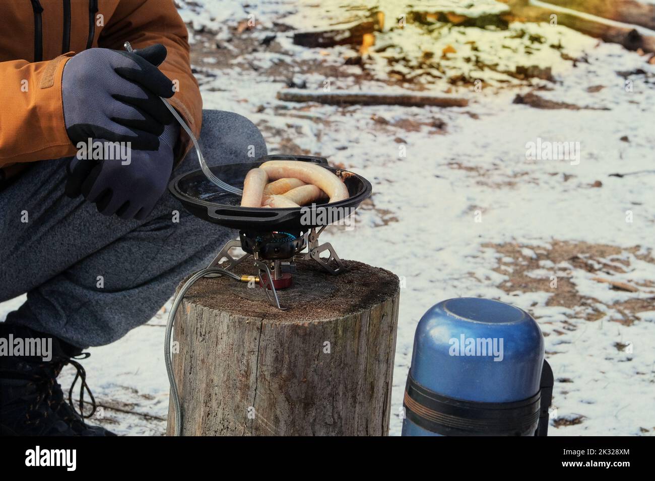 Camping food making. Foods in outdoor activities. Sausages in bowler in the forest in winter. Stock Photo